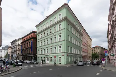 a green and white building on a city street at Central Haven Apartments in Prague
