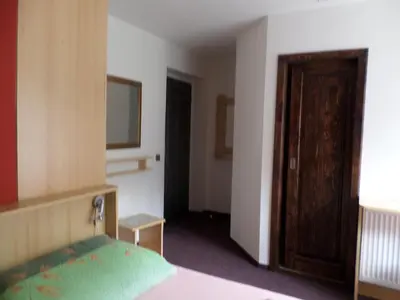 a bedroom with a bed and a wooden door at Penzion v Budech in Křivoklát