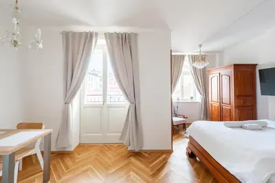 a bedroom with a bed and a desk and a window at Little Chateau in Prague