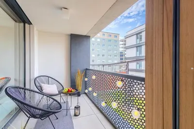 a balcony with two chairs and a table at Design Apartment - Balcony, Free Parking, Yoga, 10 mins to center, by Gravity Prague in Prague