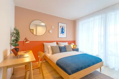 a bedroom with a bed and a table and a mirror at Design Apartment - Balcony, Free Parking, Yoga, 10 mins to center, by Gravity Prague in Prague