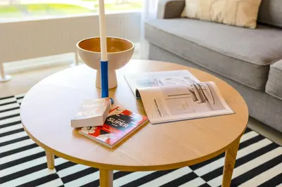 a coffee table with a book and a candle on it at Design Apartment - Balcony, Free Parking, Yoga, 10 mins to center, by Gravity Prague in Prague