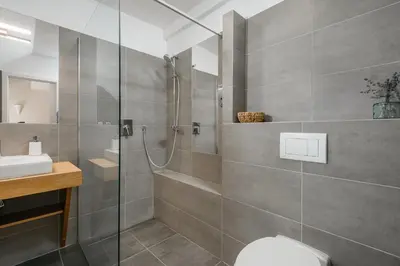 a bathroom with a shower and a toilet and a sink at ROY 2 bdr Apartment with Prague Castle View, Parking & AC in Prague