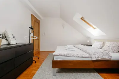 a white bedroom with a bed and a dresser at ROY 2 bdr Apartment with Prague Castle View, Parking & AC in Prague