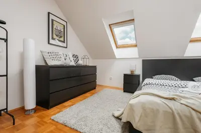 a bedroom with a bed and a black dresser at ROY 2 bdr Apartment with Prague Castle View, Parking & AC in Prague