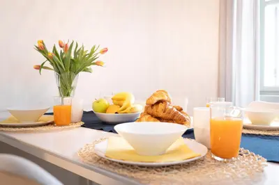 a table with a breakfast of fruit and orange juice at U Zlaté hvězdy Kalich in Litoměřice