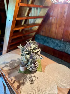 a glass table with a vase with flowers on it at Chata Markétka in Křivoklát
