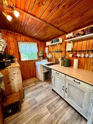 a kitchen with wooden walls and a wooden floor at Chata Markétka in Křivoklát