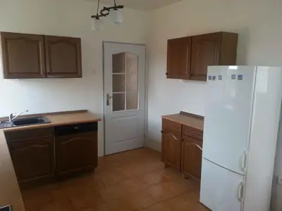 a kitchen with a white refrigerator and wooden cabinets at Holiday home in Krivoklat 1156 in Křivoklát
