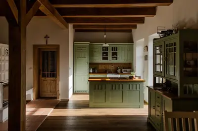 a kitchen with green cabinets and a wooden floor at Domeček v Chaloupkách in Zdice