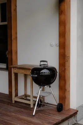 a grill sitting on a stand next to a table at Domeček v Chaloupkách in Zdice