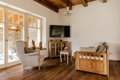 a living room with a tv and a chair and a table at Domeček v Chaloupkách in Zdice