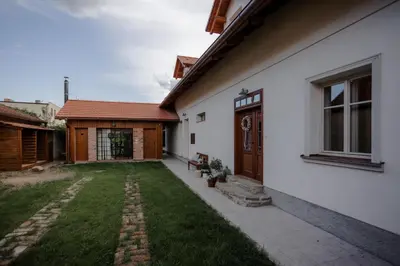 a backyard of a white house with a yard at Domeček v Chaloupkách in Zdice