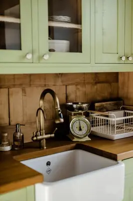 a kitchen counter with a sink and a clock at Domeček v Chaloupkách in Zdice