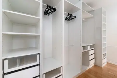 a white walk in closet with white shelves at Two-level apart with a terrace near the Vltava River in Prague
