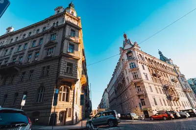 two buildings on a street with cars parked next to them at Two-level apart with a terrace near the Vltava River in Prague