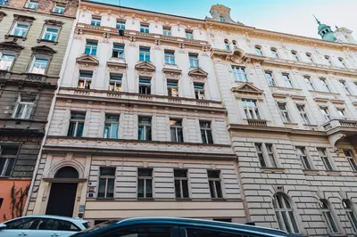 a large building with cars parked in front of it at Two-level apart with a terrace near the Vltava River in Prague