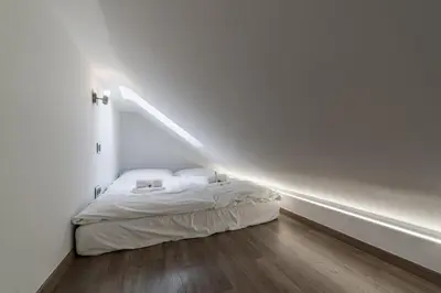 a small room with a bed in a white room at Karlín Boutique Loft Residence by LivingClub in Prague