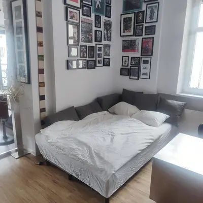 a bed in a room with pictures on the wall at Apartment Big Windows in Prague