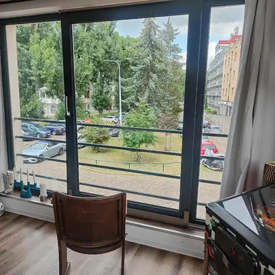 a living room with a couch and a red chair at Apartment Big Windows in Prague
