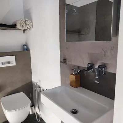 a bathroom with a white sink and a toilet at Apartment Big Windows in Prague