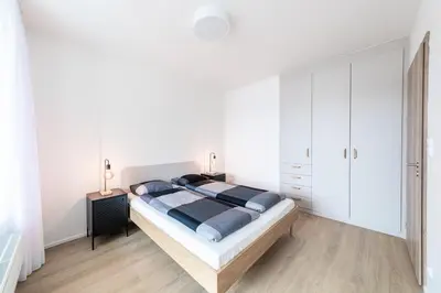 a bedroom with a large bed and white cabinets at Residence Mozaika in Prague