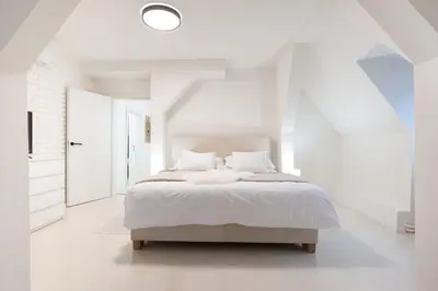 a white bedroom with a bed in a white room at U Zlaté hvězdy Zeibich in Litoměřice