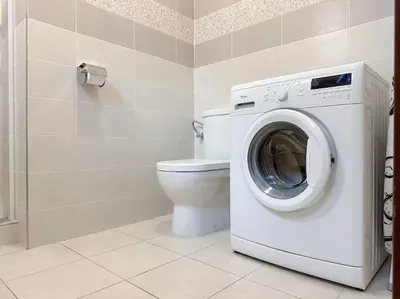 a bathroom with a washing machine and a toilet at Calm Wenceslas Square Apartment in Prague