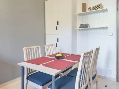 a dining room table with four chairs and a bowl of fruit on it at Calm Wenceslas Square Apartment in Prague