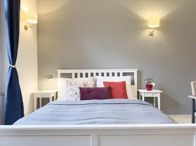 a white bed with colorful pillows on it at Calm Wenceslas Square Apartment in Prague