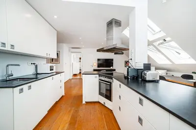 a kitchen with white cabinets and black counter tops at Luxurious 3bed very spacious apt in the best area in Prague