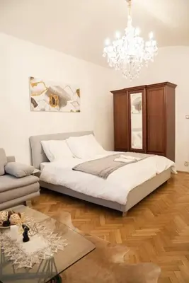 a bedroom with a bed and a chandelier at Cozy flat by Wenceslas Square! in Prague