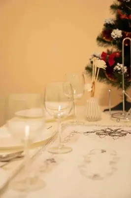 a table topped with wine glasses and a christmas tree at Cozy flat by Wenceslas Square! in Prague