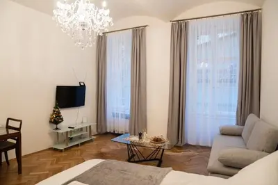 a living room with a couch and a chandelier at Cozy flat by Wenceslas Square! in Prague
