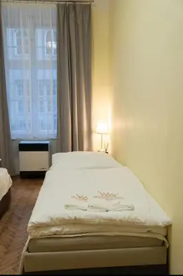 a bedroom with a white bed with a window at Cozy flat by Wenceslas Square! in Prague