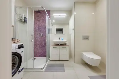 a bathroom with a toilet sink and a washing machine at Centrum Bohemia LUX in Prague