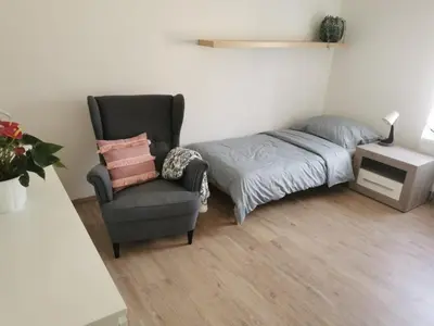 a bedroom with a bed and a chair and a bed and a desk at Apartmán Ptice in Ptice