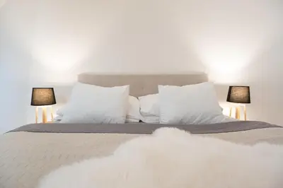 a bedroom with a bed with white pillows and two lamps at U Zlaté hvězdy Jakub in Litoměřice