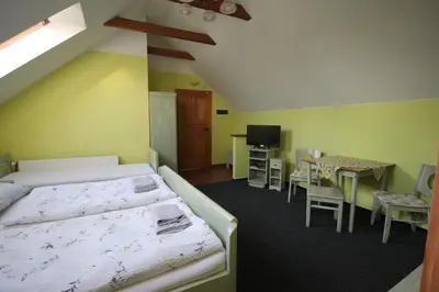 a bedroom with a bed and a table and chairs at Penzion Na Statku in Starý Vestec