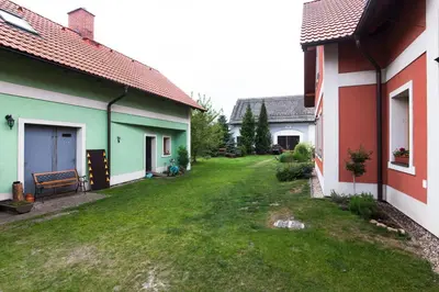 an empty yard between two houses with a green lawn at Penzion Na Statku in Starý Vestec