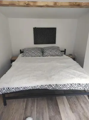 a bed with a black and white comforter in a bedroom at Klid in Budyně nad Ohří