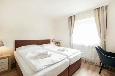 a bedroom with a bed and a chair and a window at Hotel U Císaře in Mirošovice