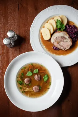 two plates of food on a wooden table at Hotel U Císaře in Mirošovice