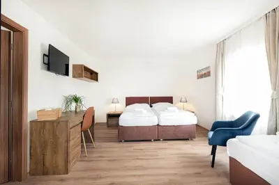 a bedroom with a bed and a desk and a tv at Hotel U Císaře in Mirošovice