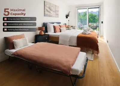 two beds and a couch in a room at Beta Home - Free Garage, Air Condition, Garden, at Metro, 2nd parking on request in Prague