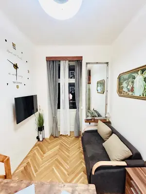 a living room with a couch and a tv at Cozy Design Homestay with terrace in Prague