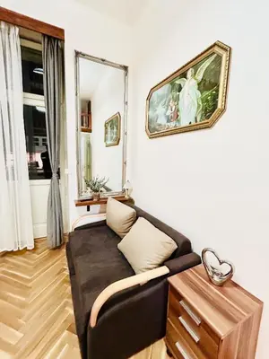 a living room with a couch and a mirror at Cozy Design Homestay with terrace in Prague