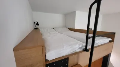 a bed in a small room with a wooden platform at Endless Jecna in Prague
