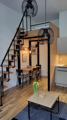 a living room with a table and a spiral staircase at Endless Jecna in Prague