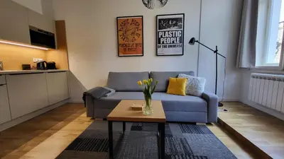 a living room with a blue couch and a coffee table at Endless Jecna in Prague